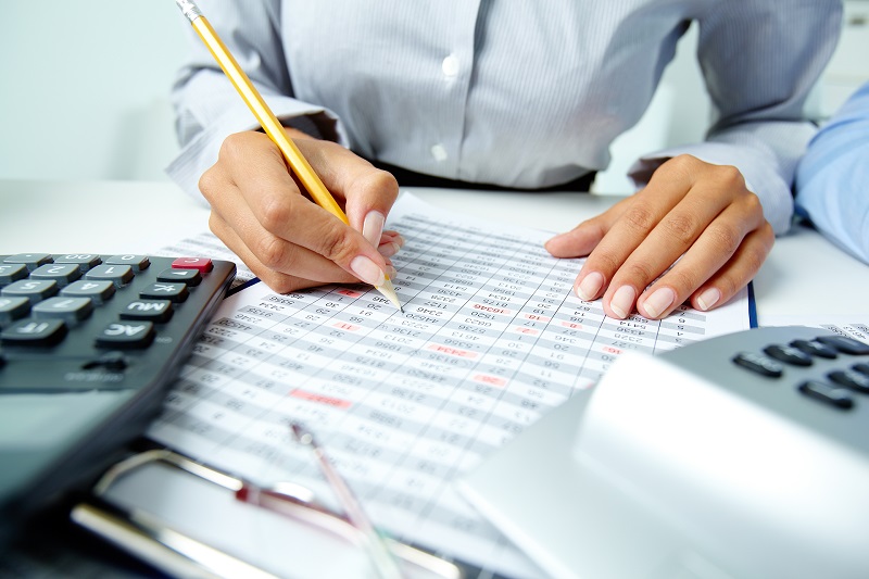 An image of a financial professional filling out spreadsheets. Bookkeeping services from Van Middlesworth and Company.